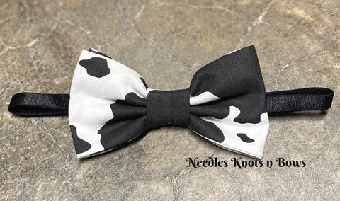 Cow print pre tied bow tie on an adjustable strap. Matching pocket square and suspenders are available to add on.