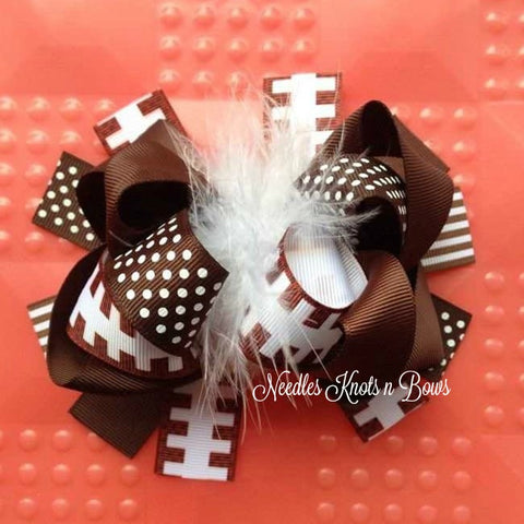 Girls 6.5" football hair bow with feather center. Alligator clip used so you can add it to a crocheted headband for little one's with less hair.
