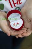 Santa's head stud earrings in a red velvet jewelry box.